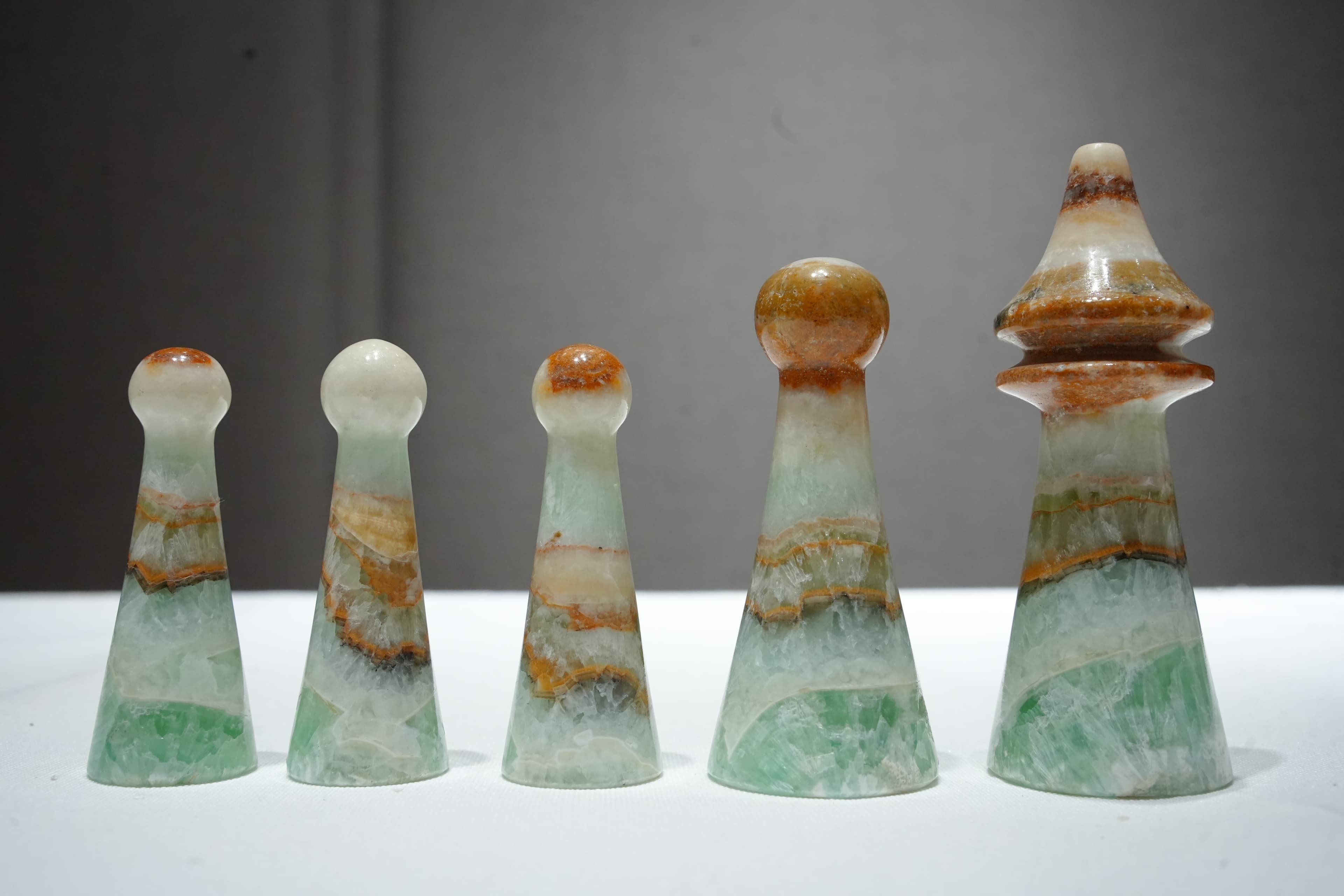 Row of five hand-carved onyx finials of varying height and profile