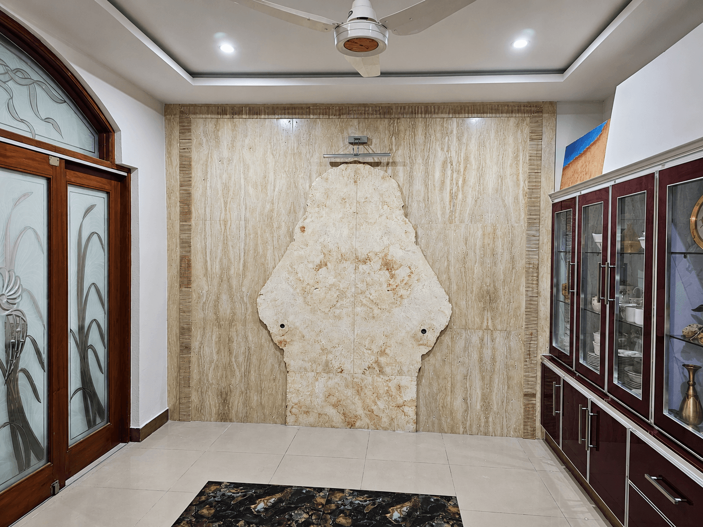 Large room with an arched organic-cut travertine slab wall feature