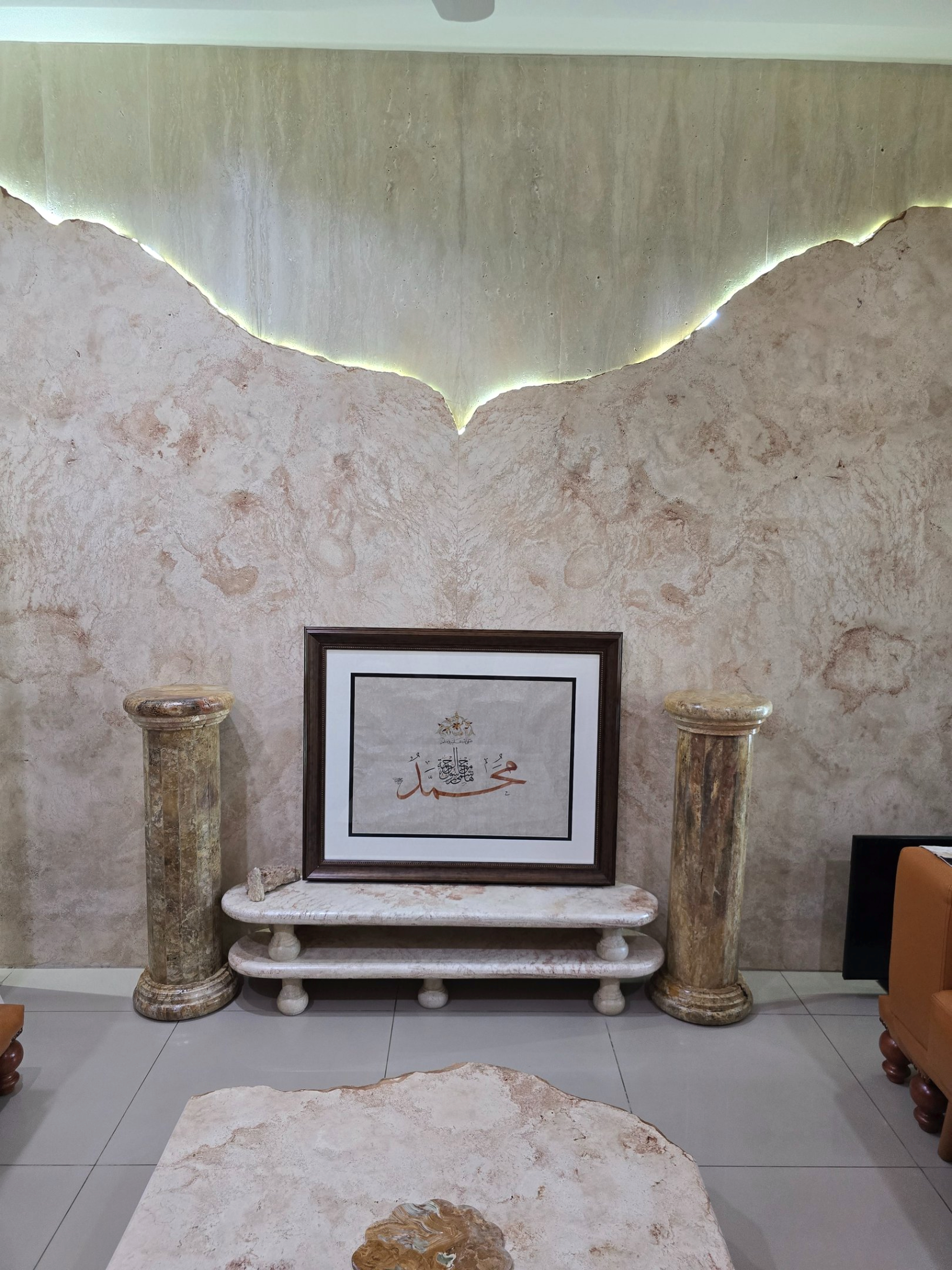 Grand foyer with travertine-clad walls, a carved wooden door, and a staircase