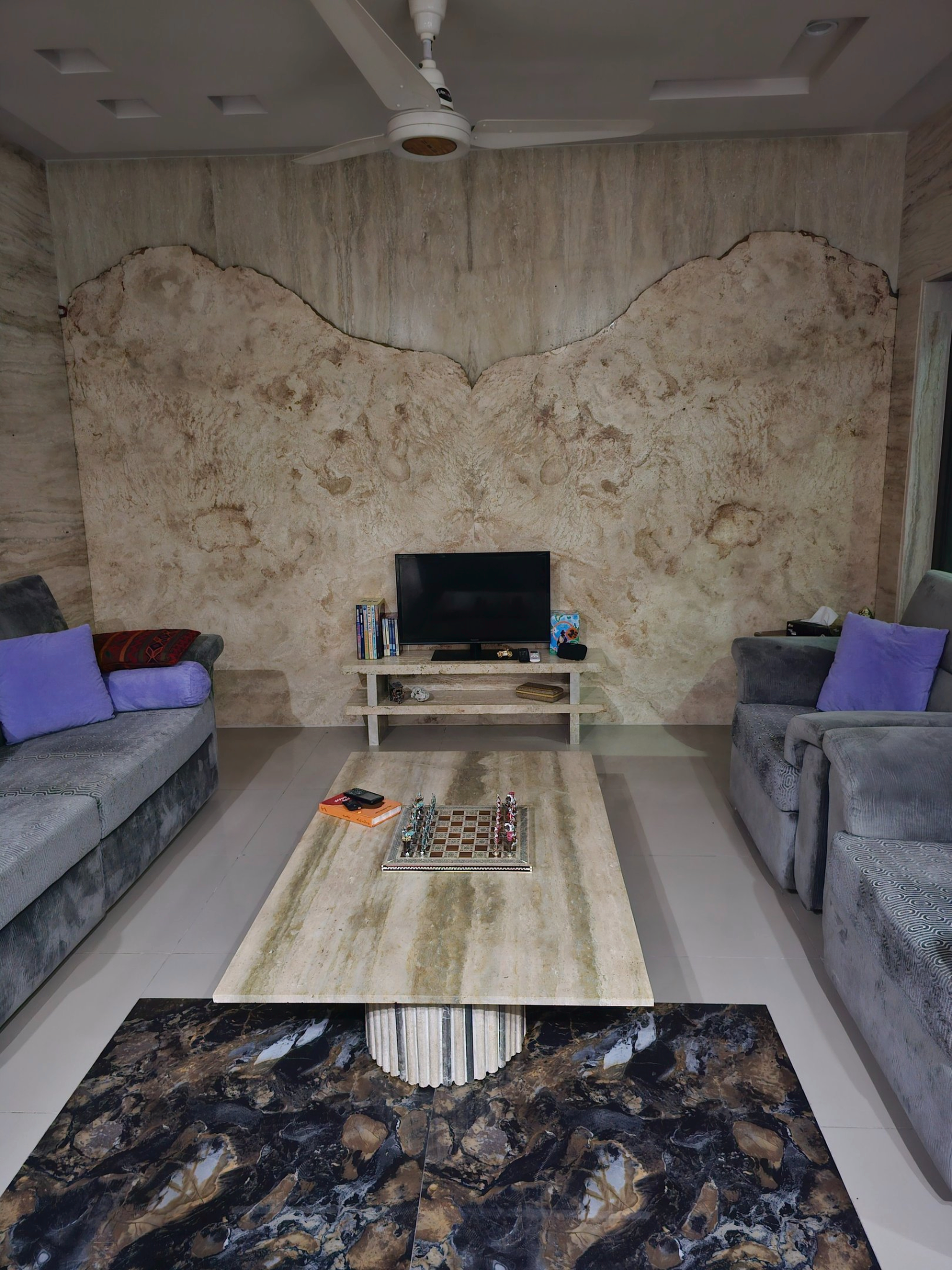Framed calligraphy artwork on a console flanked by travertine columns